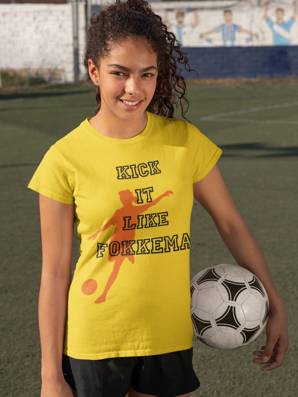 female soccer player in yellow T-shirt holding a ball
